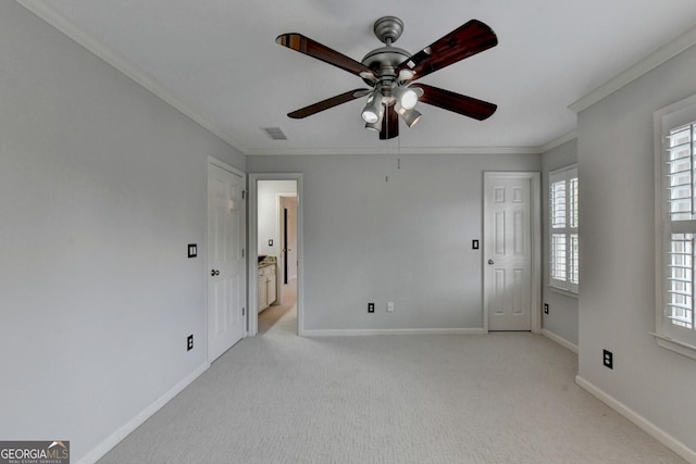 empty room featuring ceiling fan, ornamental molding, and light carpet