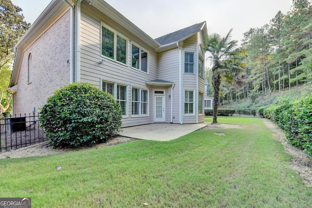 rear view of property with a yard and a patio