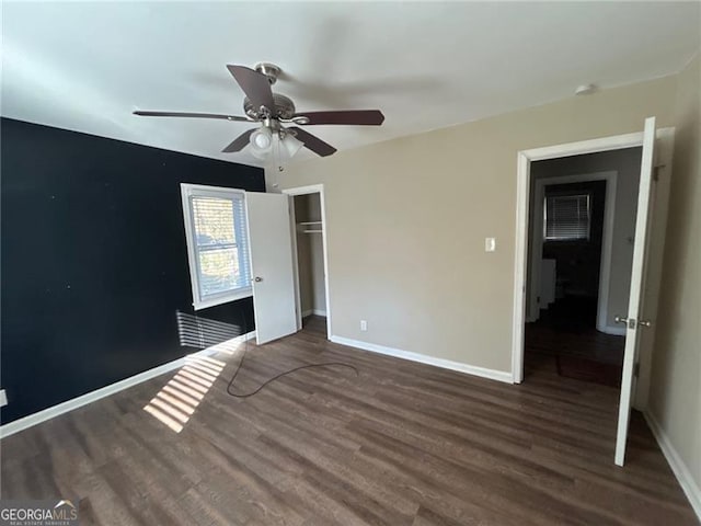 unfurnished bedroom featuring ceiling fan, dark wood-type flooring, and a closet