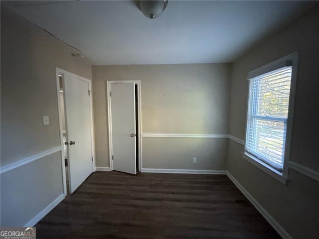 unfurnished room with dark hardwood / wood-style flooring