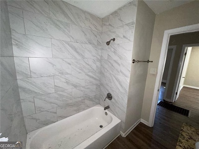 bathroom with hardwood / wood-style floors and tiled shower / bath combo