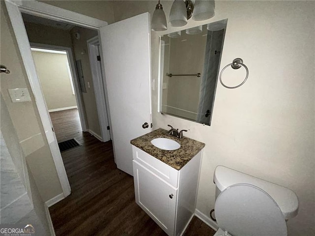 bathroom featuring vanity, hardwood / wood-style flooring, and toilet