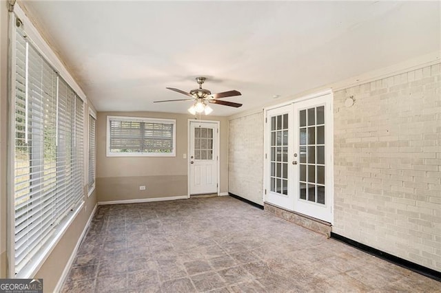 unfurnished sunroom with ceiling fan and french doors