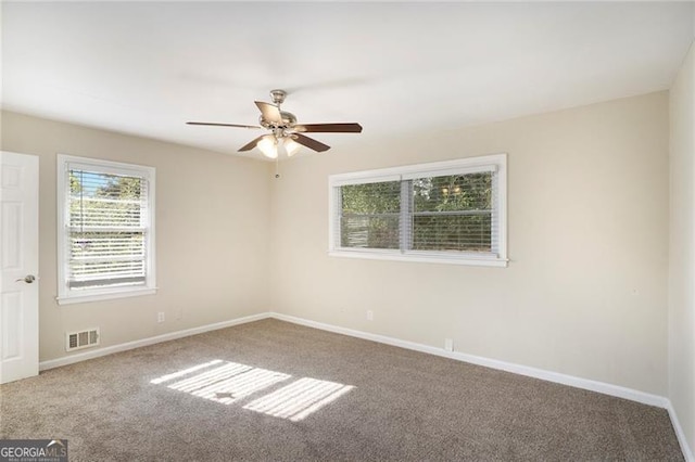 carpeted spare room featuring ceiling fan