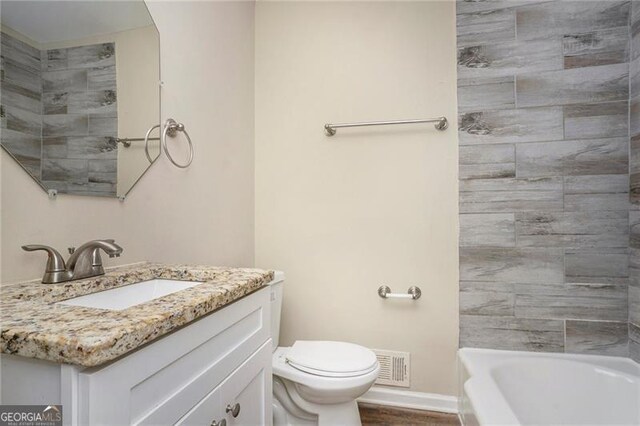 full bathroom featuring hardwood / wood-style floors, vanity, toilet, and tiled shower / bath