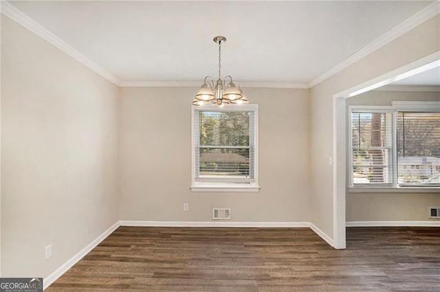 unfurnished dining area featuring dark hardwood / wood-style floors, ornamental molding, and a chandelier