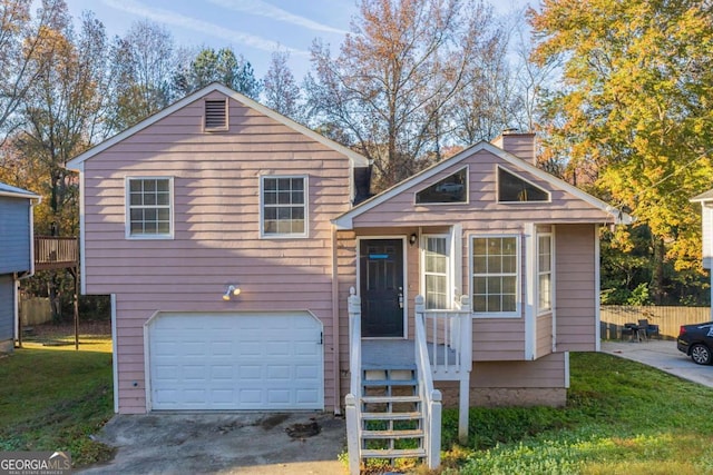 split level home with a garage and a front lawn