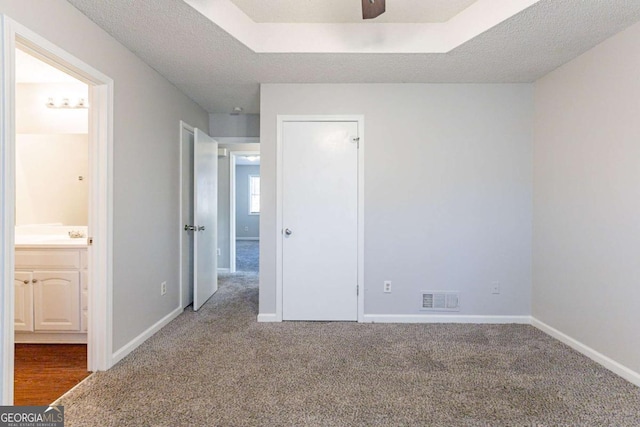 unfurnished bedroom featuring carpet, a textured ceiling, and connected bathroom