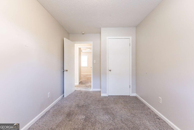 unfurnished bedroom featuring carpet and a textured ceiling