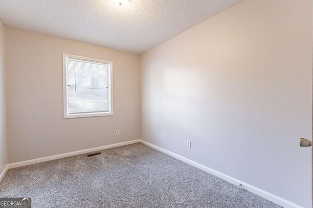 unfurnished room featuring a textured ceiling and carpet floors