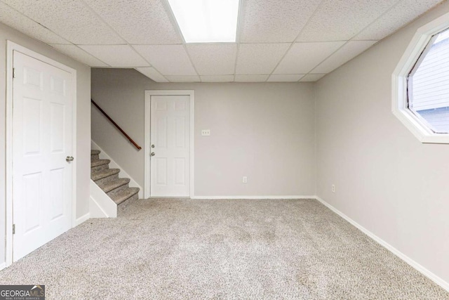 basement with carpet floors and a paneled ceiling