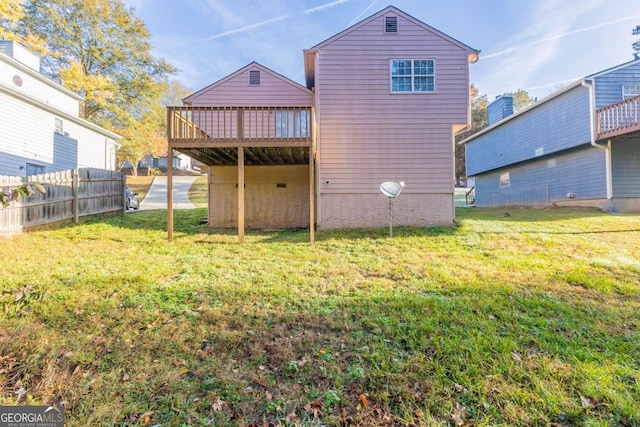 rear view of property with a yard and a deck