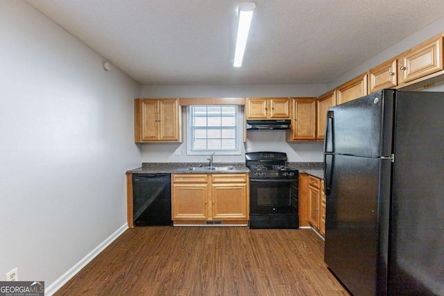 kitchen featuring a textured ceiling, sink, dark hardwood / wood-style floors, and black appliances