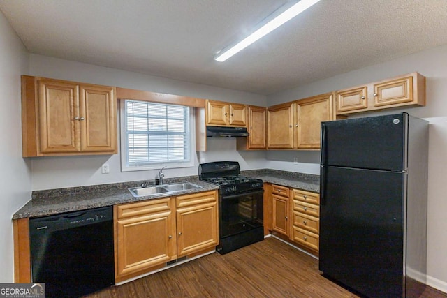 kitchen featuring a textured ceiling, sink, black appliances, and dark hardwood / wood-style floors