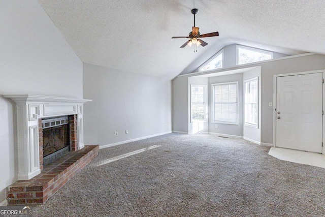 unfurnished living room featuring carpet flooring, a brick fireplace, a textured ceiling, vaulted ceiling, and ceiling fan