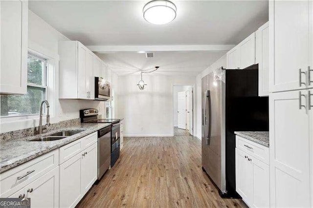 kitchen featuring light stone countertops, white cabinetry, sink, and stainless steel appliances