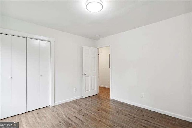 unfurnished bedroom with hardwood / wood-style floors and a closet