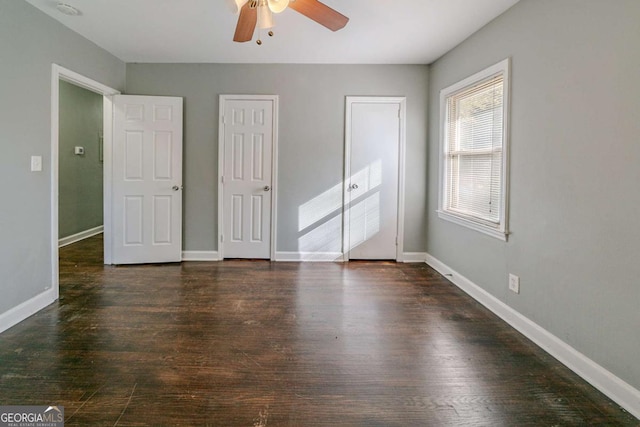 unfurnished bedroom with ceiling fan and dark wood-type flooring