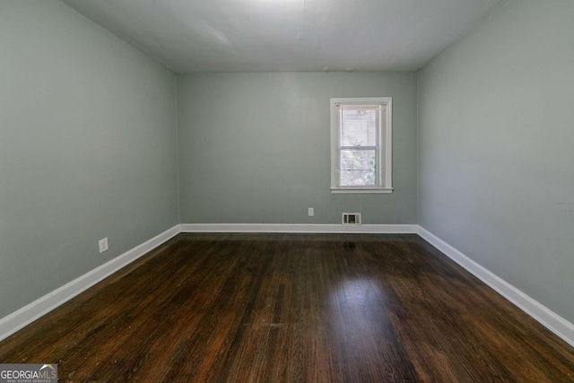 empty room featuring dark wood-type flooring