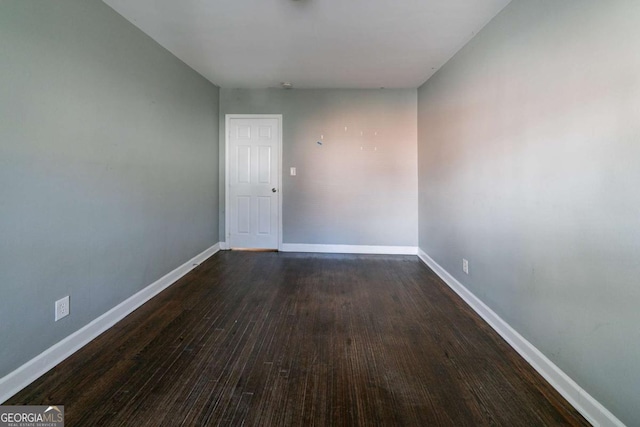 empty room with dark hardwood / wood-style flooring