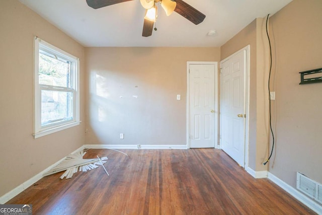 spare room with ceiling fan and dark wood-type flooring