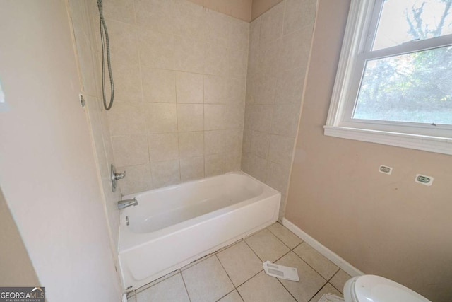 bathroom with tile patterned flooring, tiled shower / bath combo, and toilet