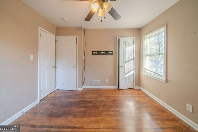 empty room featuring ceiling fan and dark hardwood / wood-style flooring