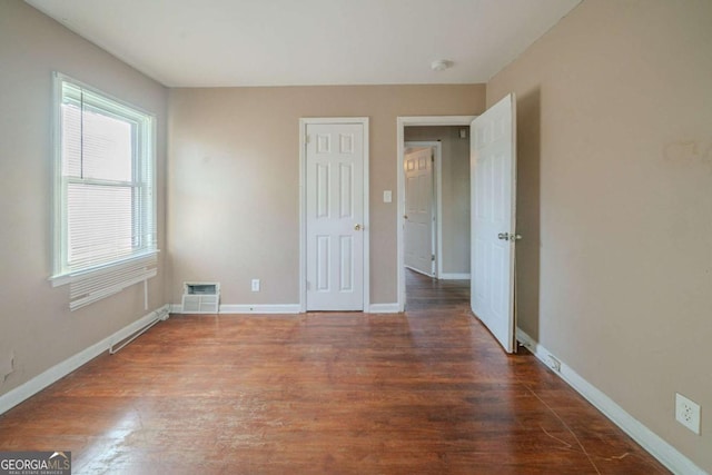 spare room with dark hardwood / wood-style flooring and a baseboard radiator