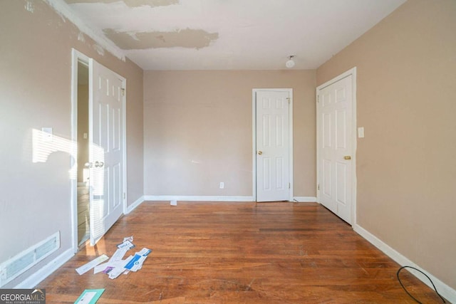 unfurnished bedroom featuring dark hardwood / wood-style floors