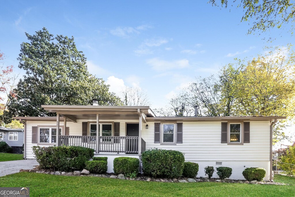 ranch-style home with covered porch and a front lawn