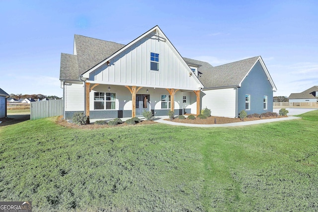 modern inspired farmhouse with board and batten siding, covered porch, a shingled roof, and a front lawn