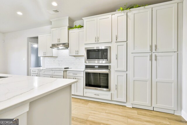 kitchen with pendant lighting, light wood-type flooring, and white cabinetry