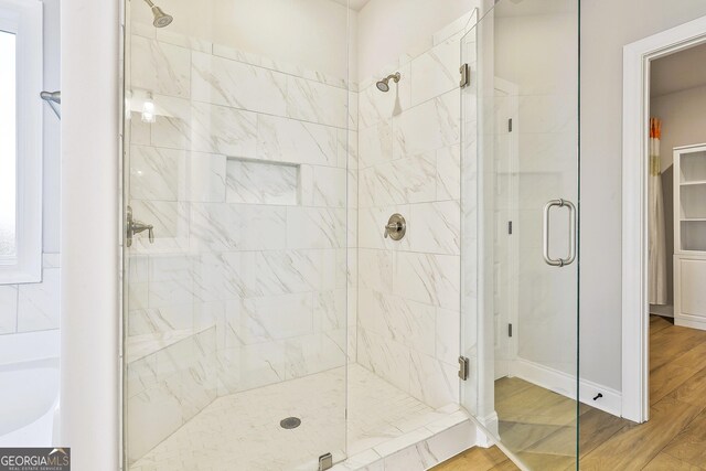 bathroom with separate shower and tub and hardwood / wood-style flooring