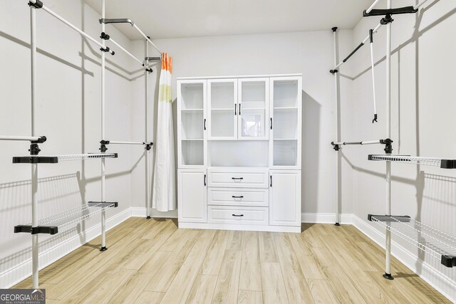 bathroom with wood-type flooring and an enclosed shower