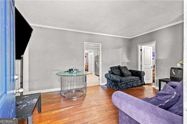 living room with crown molding, a textured ceiling, and hardwood / wood-style flooring