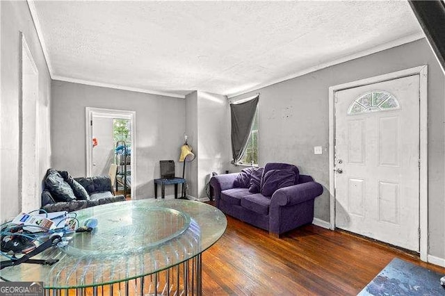 living room featuring dark hardwood / wood-style floors, a textured ceiling, and ornamental molding