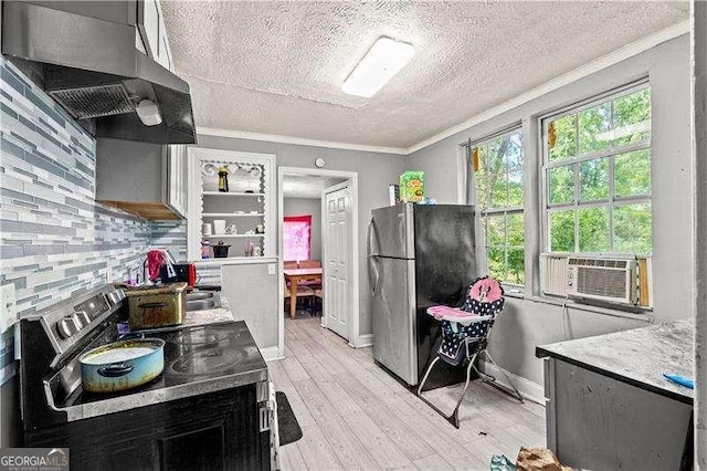 kitchen with wall chimney exhaust hood, stainless steel appliances, backsplash, crown molding, and light wood-type flooring