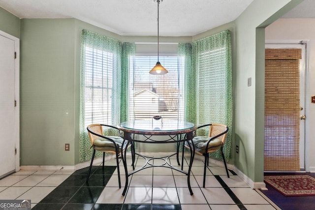 tiled dining space with a textured ceiling