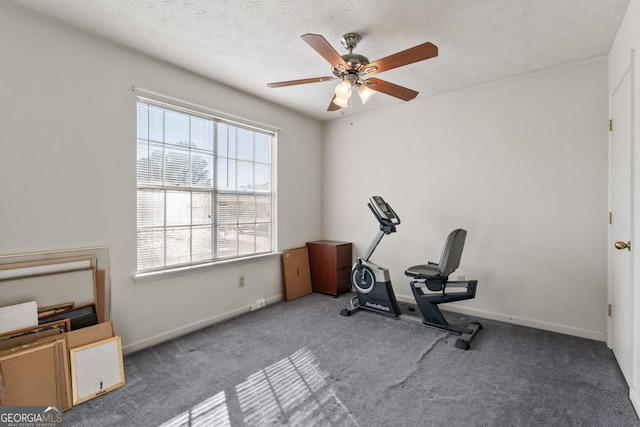 exercise area with carpet flooring, ceiling fan, and a textured ceiling