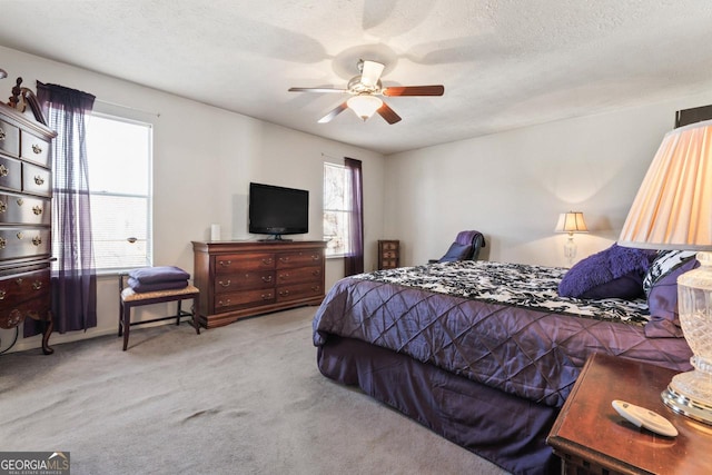 carpeted bedroom with a textured ceiling and ceiling fan