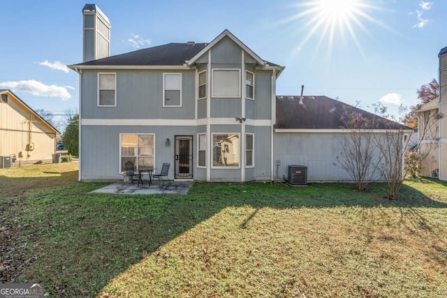 rear view of house with a yard, cooling unit, and a patio