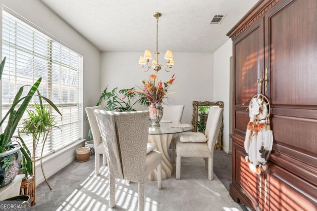 carpeted dining area featuring an inviting chandelier and a healthy amount of sunlight