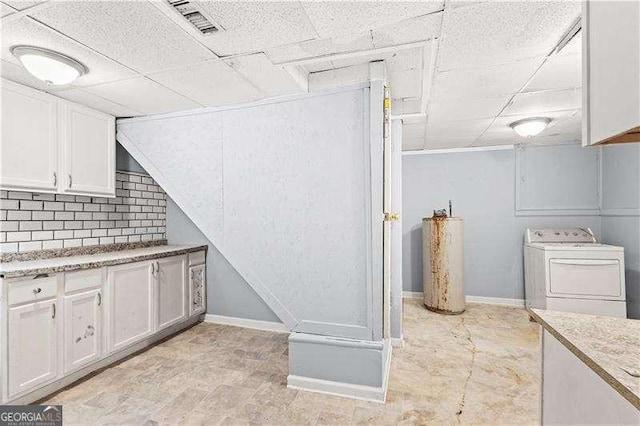 kitchen with washer / dryer, white cabinetry, a drop ceiling, and water heater