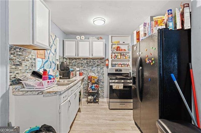 kitchen with black refrigerator with ice dispenser, white cabinets, light wood-type flooring, tasteful backsplash, and stainless steel range oven