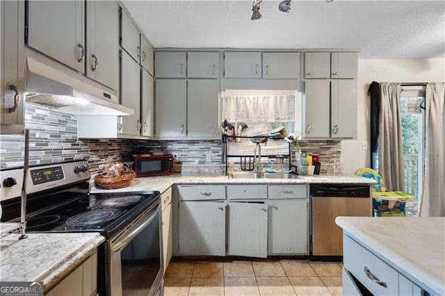 kitchen featuring appliances with stainless steel finishes, gray cabinetry, a textured ceiling, sink, and light tile patterned floors