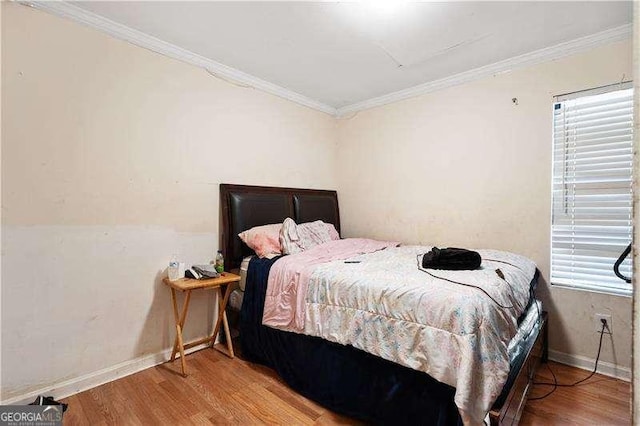 bedroom with light hardwood / wood-style floors and ornamental molding