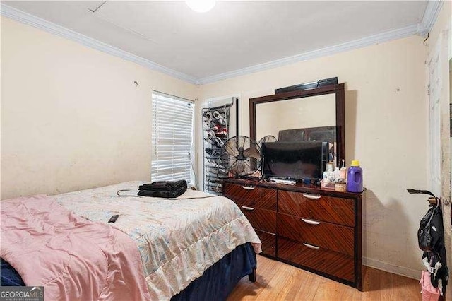 bedroom with ornamental molding and light wood-type flooring