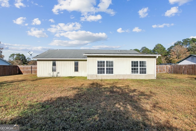 rear view of property featuring a lawn