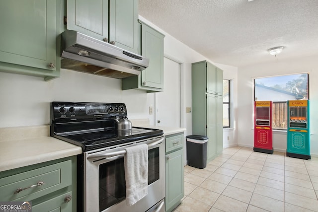 kitchen with light tile patterned floors, a textured ceiling, stainless steel electric range oven, and green cabinets