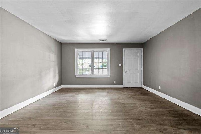 empty room with dark hardwood / wood-style floors